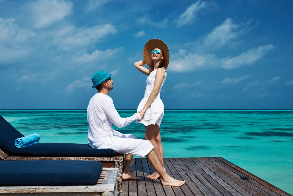Honeymoon couple on their private balcony overlooking the crystal clear Caribbean Sea