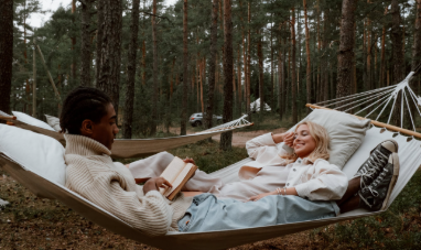 A couple unwinds in a hammock while enjoying a quiet nature escape.