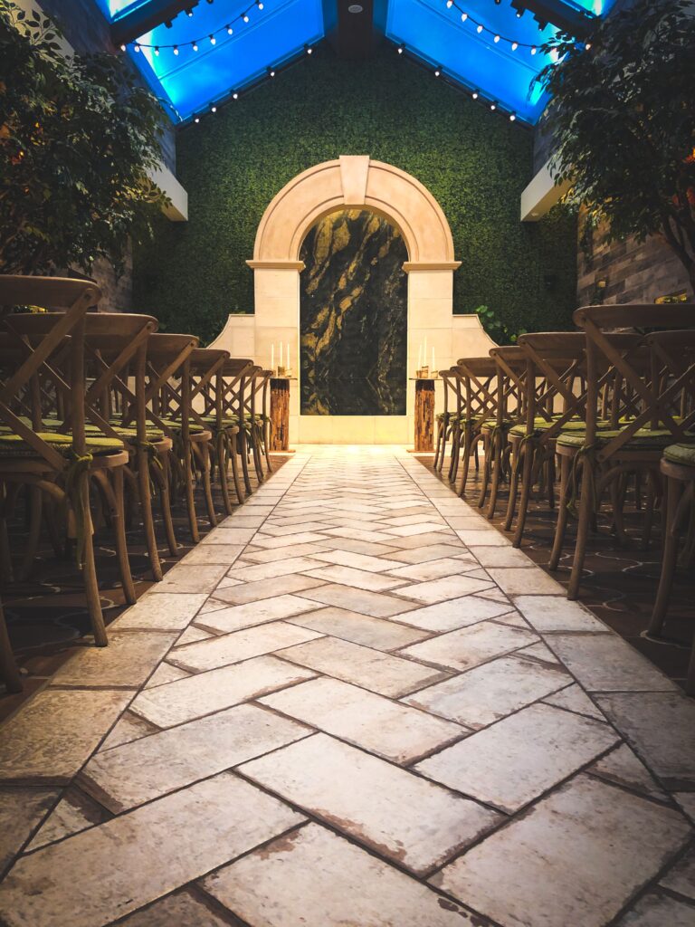 wedding venue with wooden chairs and illuminated arch