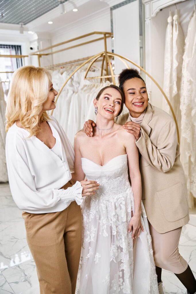 beautiful bride in a white dress, standing gracefully side by side with mother and bridesmaid