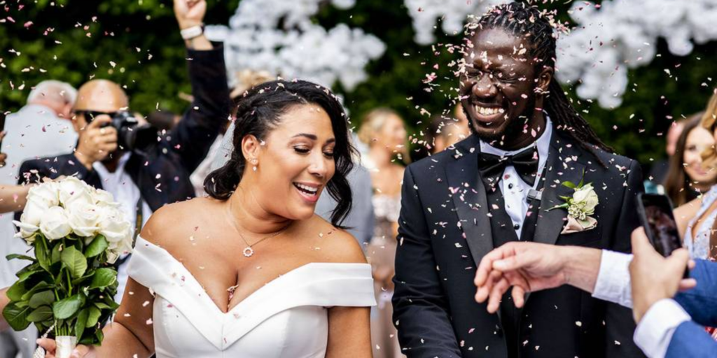 Newlywed couple walking through guests during celebration