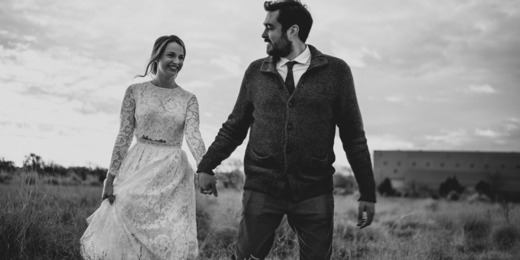 Newlywed couple walking hand in hand outdoors after their wedding ceremony