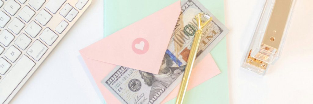 Wedding budget planning with cash, stationery, and a pen on a desk