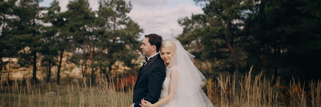 Couple portraits at an outdoor summer wedding in evening light.